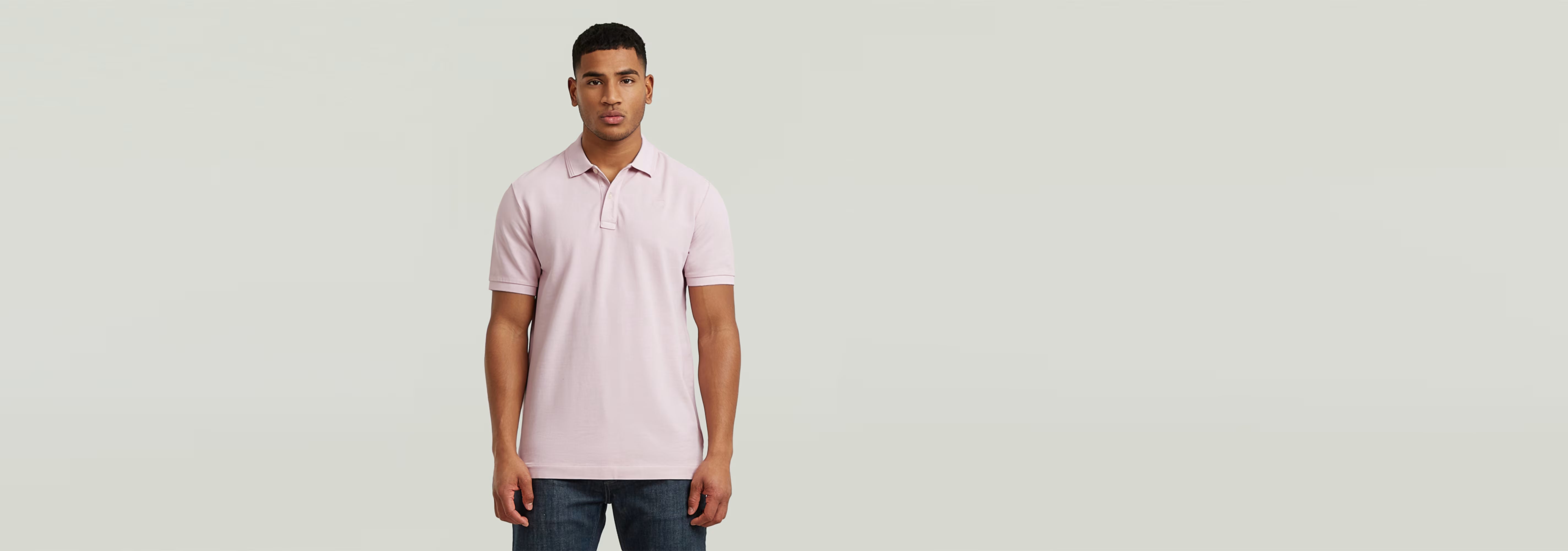 Hombre vistiendo el Polo Dunda Overdyed Slim color rosa, con diseño clásico y cierre de botones.