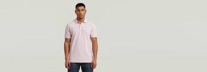 Hombre vistiendo el Polo Dunda Overdyed Slim color rosa, con diseño clásico y cierre de botones.