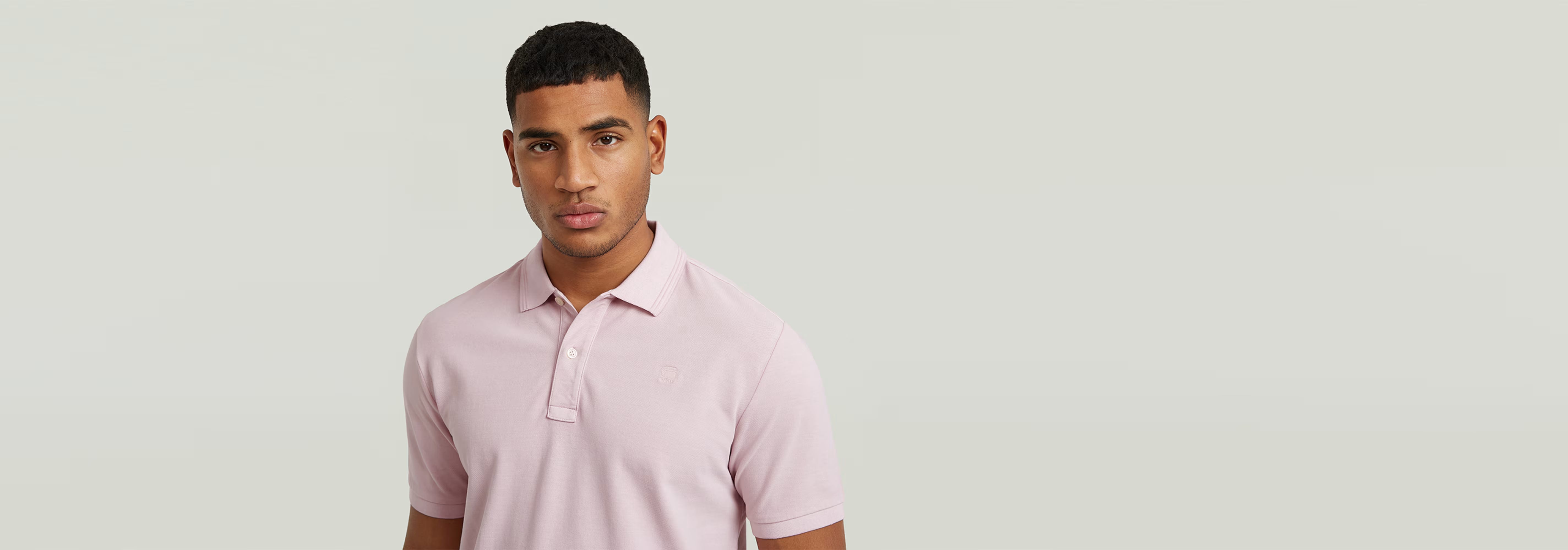 Polo Dunda Overdyed Slim model wearing a light pink polo shirt with a classic design and button closure.