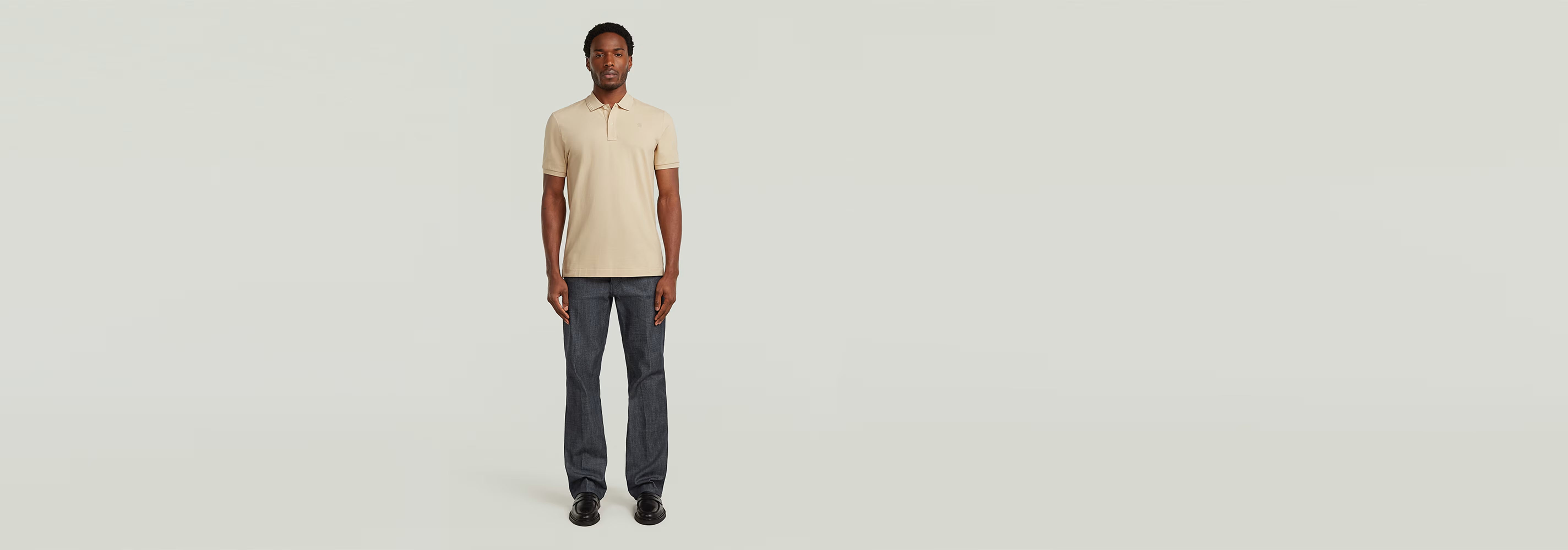 Hombre vistiendo el Polo Dunda Slim color beige frente a un fondo neutro.