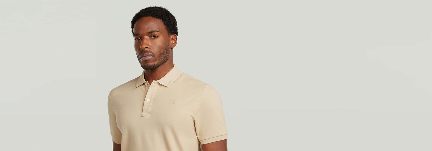 Modelo luciendo el Polo Dunda Slim en color beige, con cierre de botones y cuello acanalado.