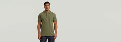 Hombre usando el Polo Dunda Slim en color verde, con corte ajustado y cierre de polo auténtico.