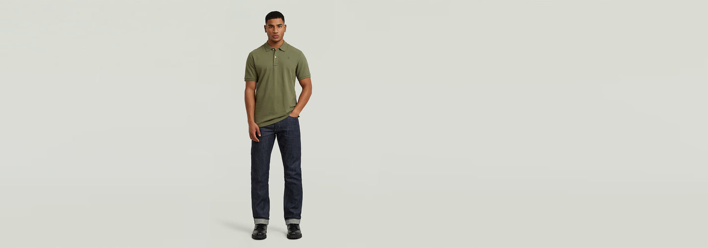 Modelo vistiendo el Polo Dunda Slim en color verde, combinado con jeans oscuros.