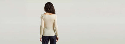 Mujer de espaldas vistiendo el suéter ajustado Punto ajustado Engineered Sheer en color beige.