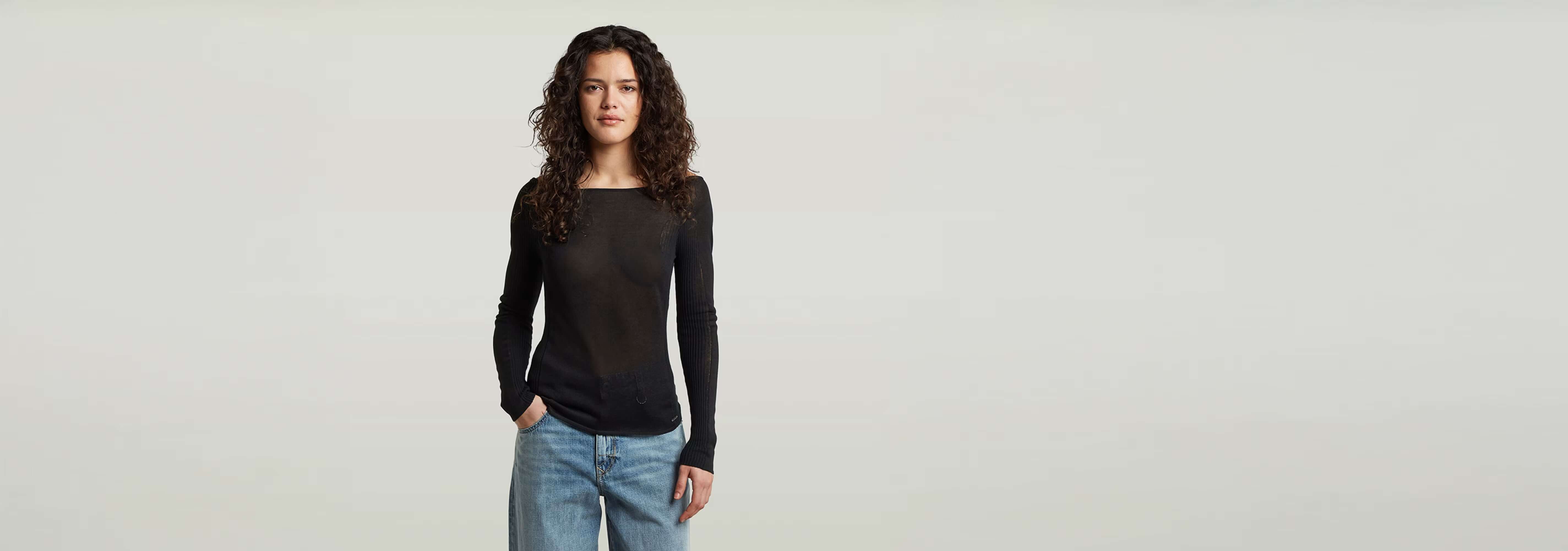 Mujer usando el suéter Punto ajustado Engineered Sheer, con jeans, fondo claro.