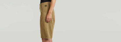Shorts Bermuda en color beige con ajuste ancho y cintura baja, mostrando diseño clásico y moderno.