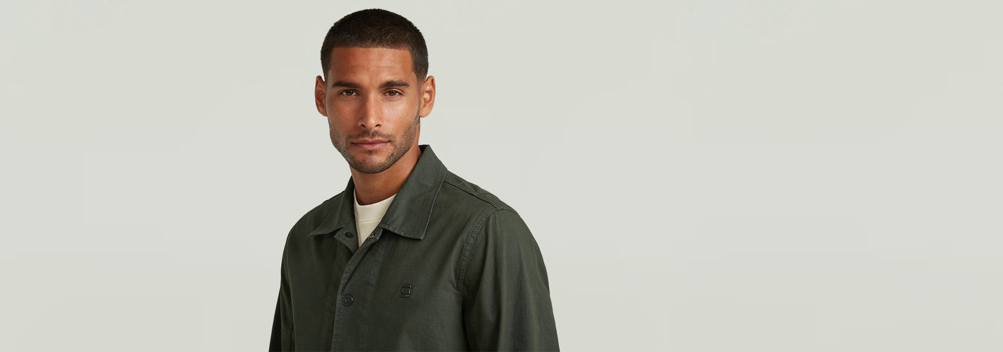 Sobrecamisa 2 Pocket en un hombre con corte ajustado y color verde, frente a fondo neutro.