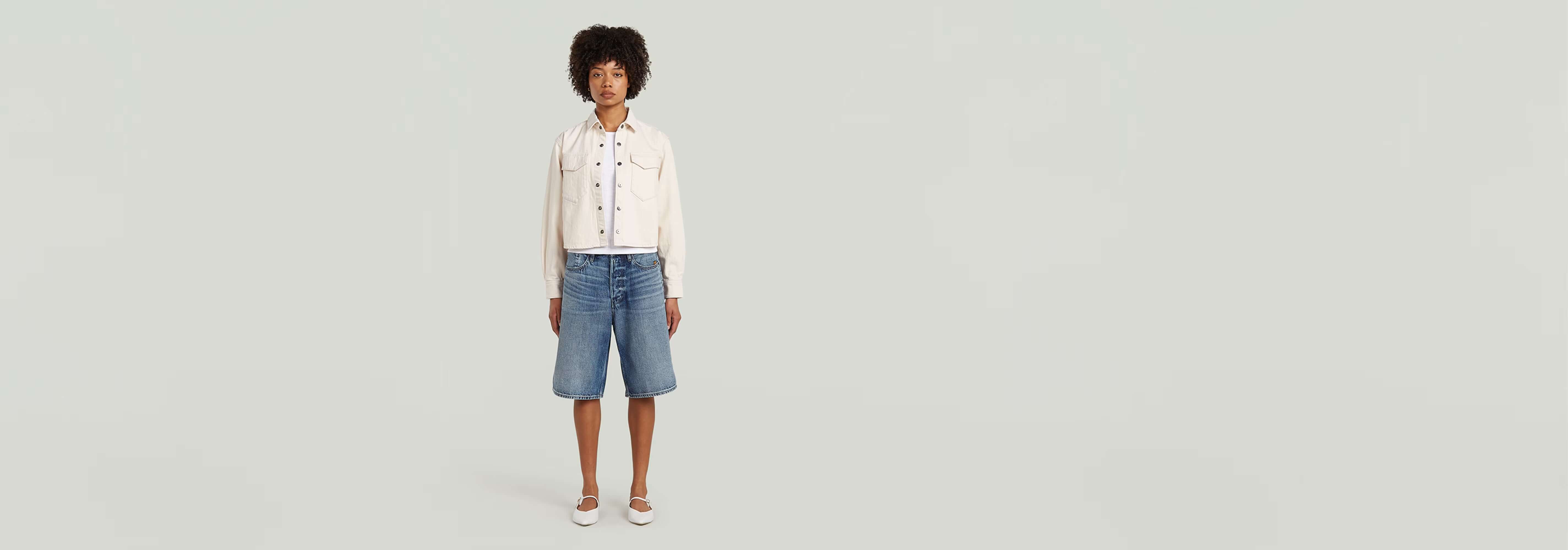 Modelo usando la sobrecamisa Boxy Relaxed con pantalones cortos en un fondo neutro.