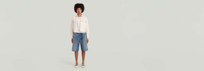 Modelo usando la sobrecamisa Boxy Relaxed con pantalones cortos en un fondo neutro.