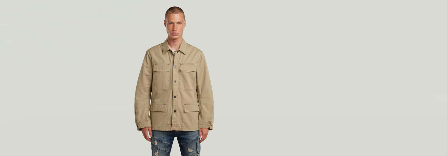 Hombre usando la Sobrecamisa Reversible 4 Pocket de color beige con cuatro bolsillos, look elegante y versátil.