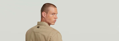 Hombre con sobracamisa reversible 4 pocket, mostrando el diseño elegante y funcional desde atrás.