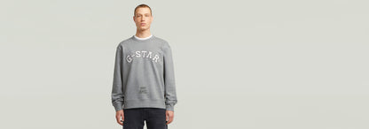 Hombre vistiendo sudadera de algodón con diseño gráfico G-STAR en fondo neutro, Sudadera Applique.