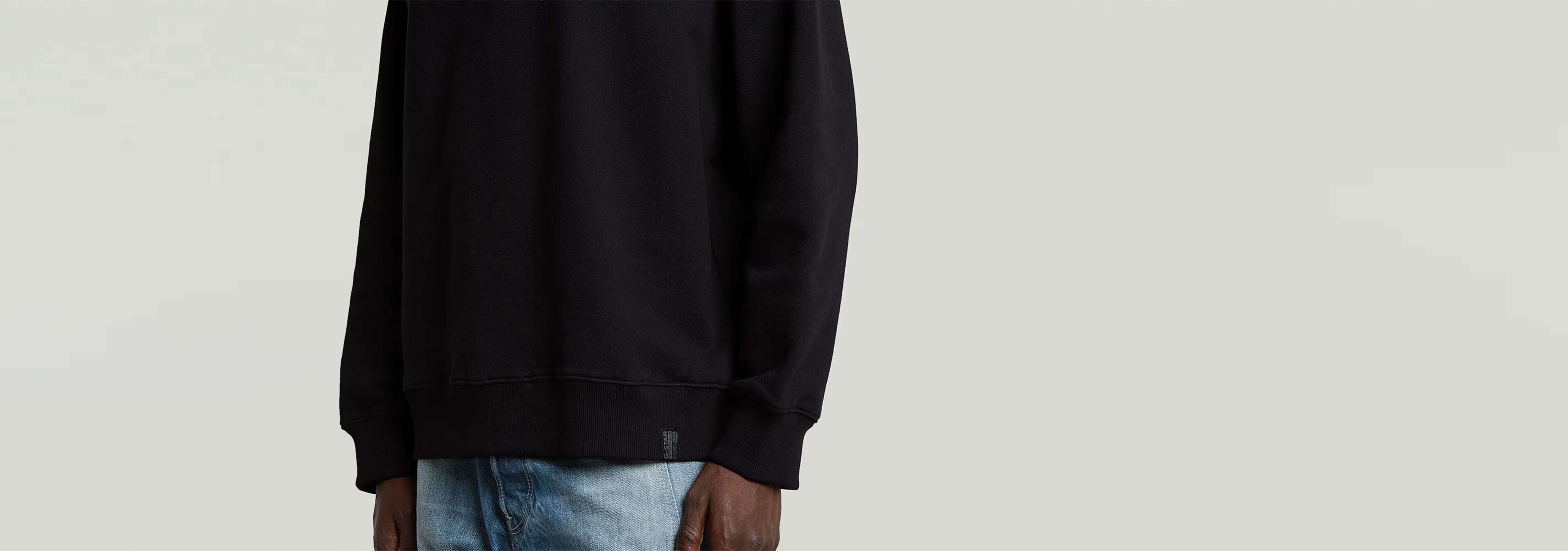 Sudadera GS-01 Relaxed, sudadera negra de corte relajado con manga larga y cuello redondo, 100% algodón ecológico.
