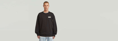 Sudadera HB Badge en color negro con diseño atractivo y corte relajado, ideal para cualquier armario.
