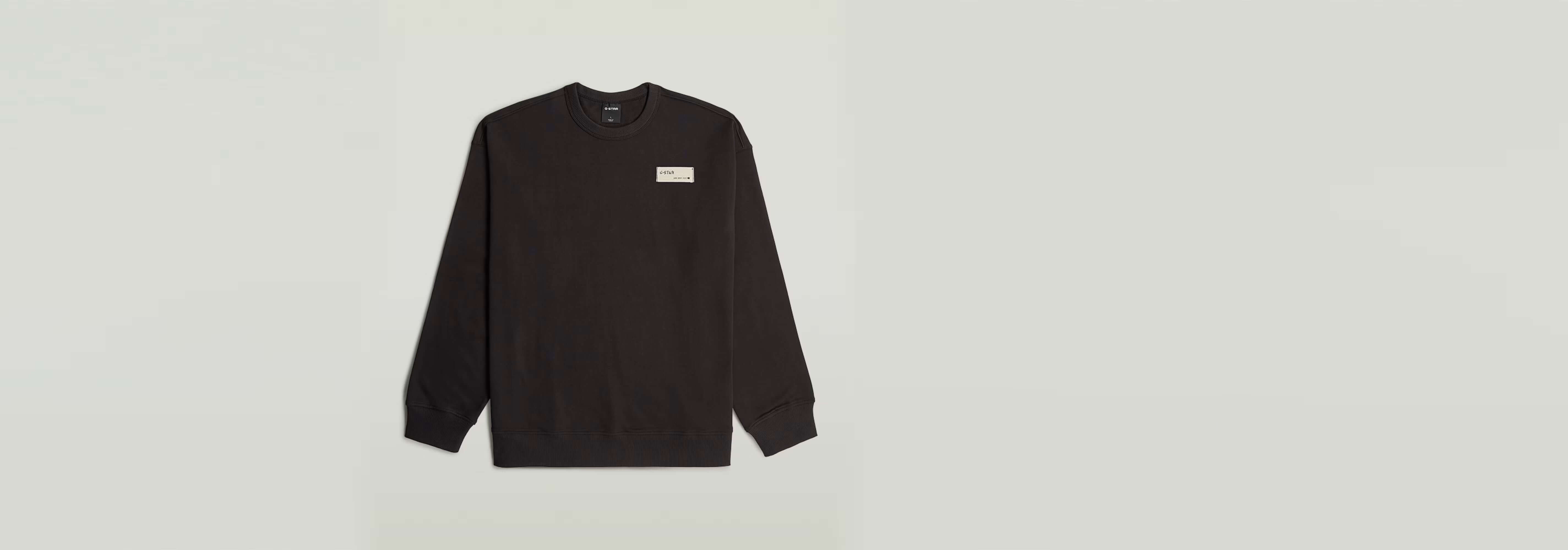 Sudadera HB Badge negra con corte relajado, 100% algodón ecológico y diseño atractivo.