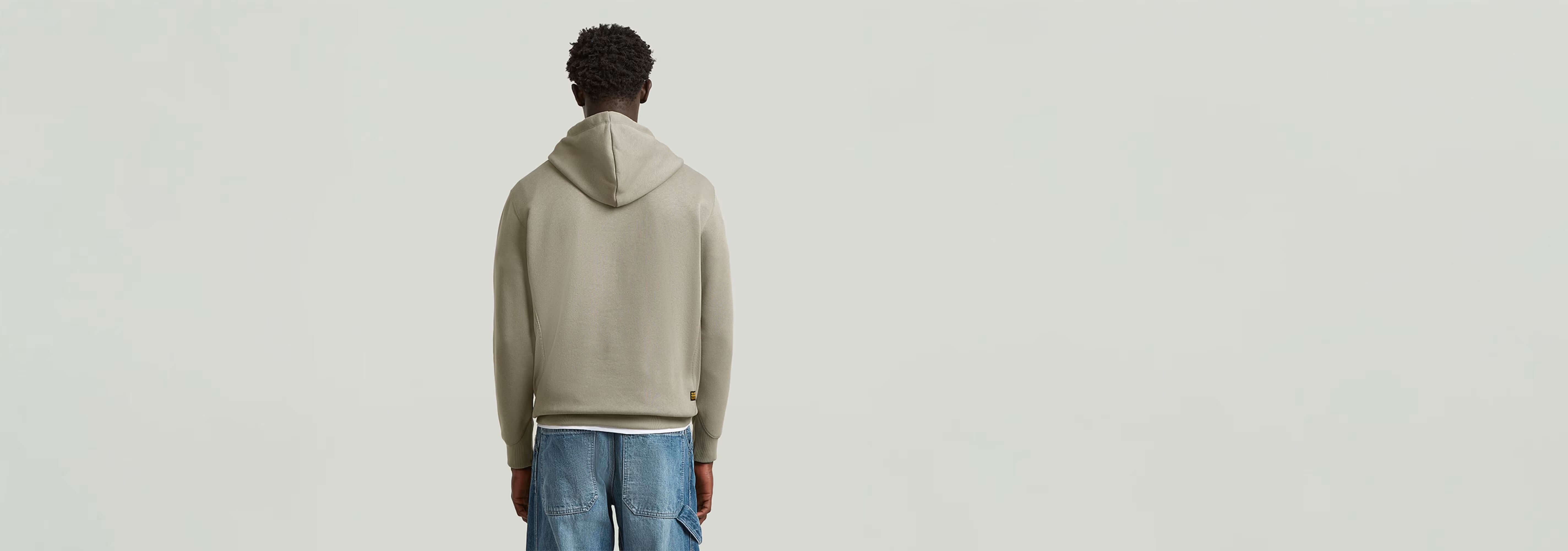 Hombre mostrando la espalda de la Sudadera Premium Core Hoodie con capucha, material suave y duradero.