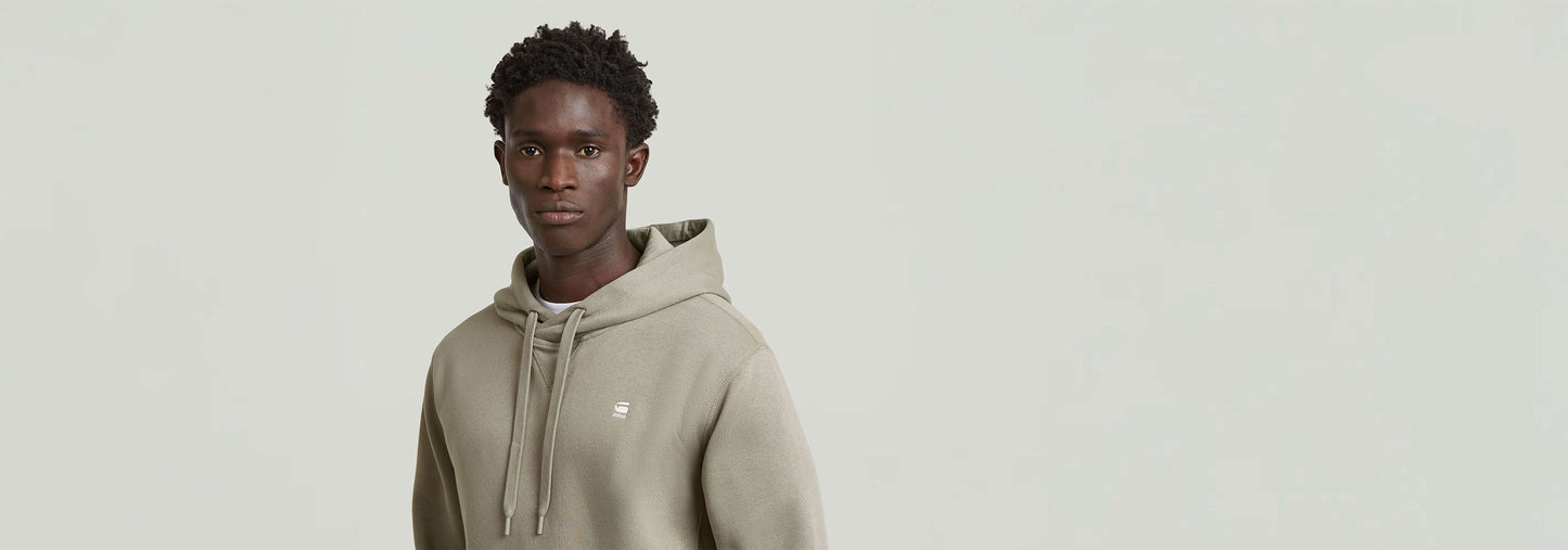 Sudadera Premium Core Hoodie en color verde oliva, con capucha y detalles gráficos sutiles.