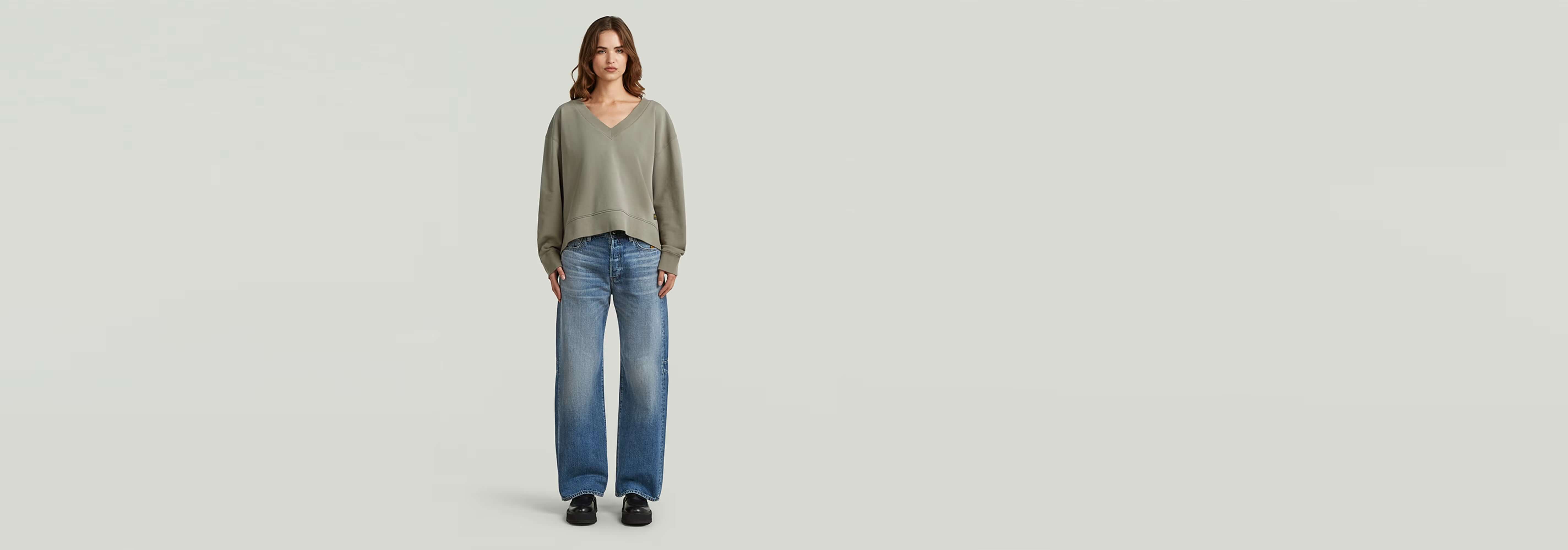 Mujer usando el Suéter Sunfaded V-Neck Loose con jeans en un fondo claro.