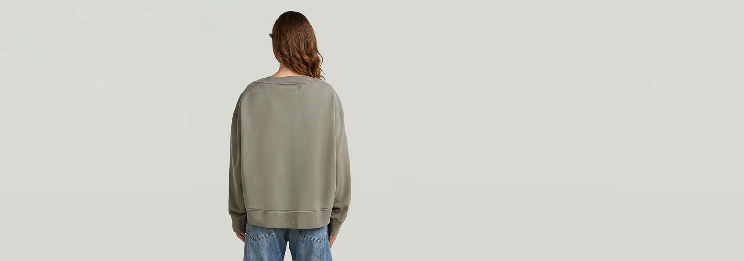 Mujer vista de espaldas en suéter Sunfaded V-Neck Loose, con corte relajado y color descolorido por el sol.