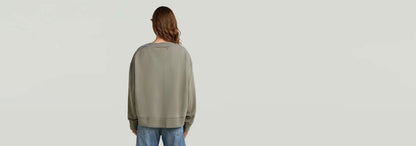 Mujer vista de espaldas en suéter Sunfaded V-Neck Loose, con corte relajado y color descolorido por el sol.