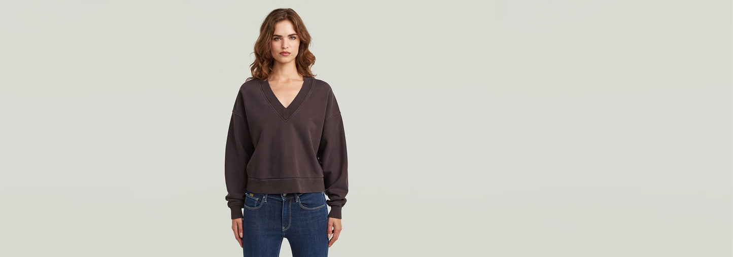 Imagen de mujer usando un suéter Washed Loose V de corte extragrande, con cuello de pico y efecto lavado.