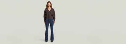 Suéter Washed Loose V en modelo con pantalones de campana, corte extragrande y cuello de pico, en tela de algodón ecológico.