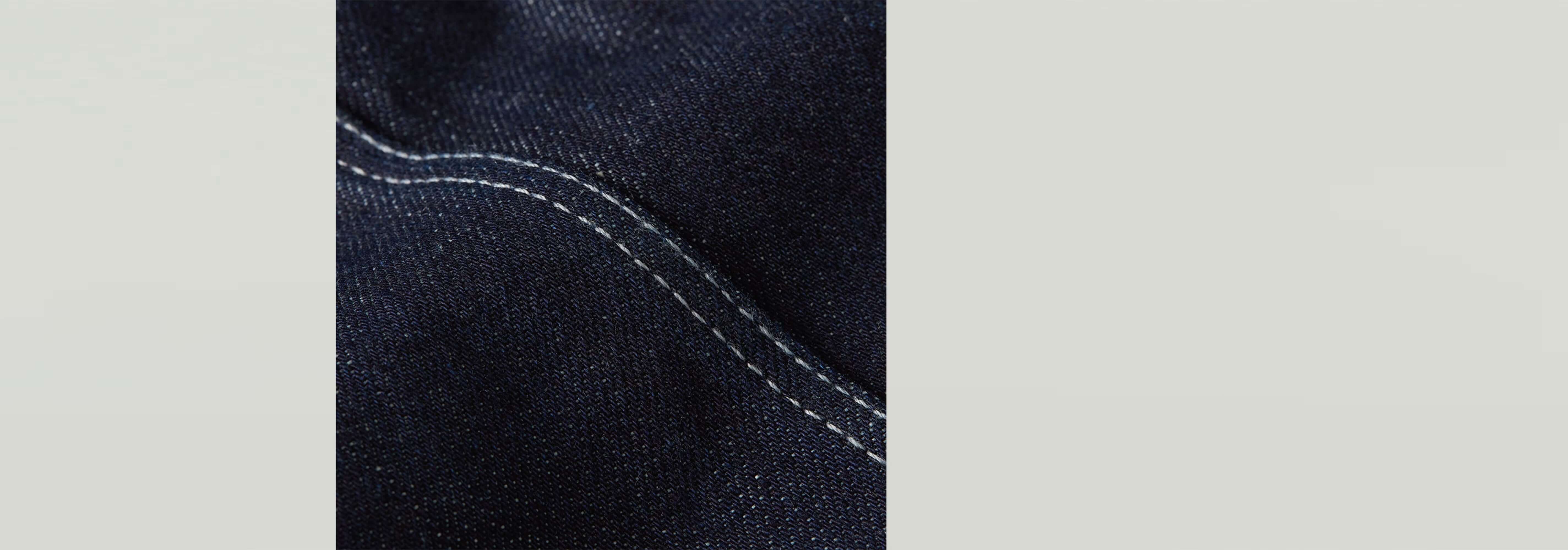 Close-up of Top Kick Bustier fabric with dark denim texture and contrasting white stitching details.