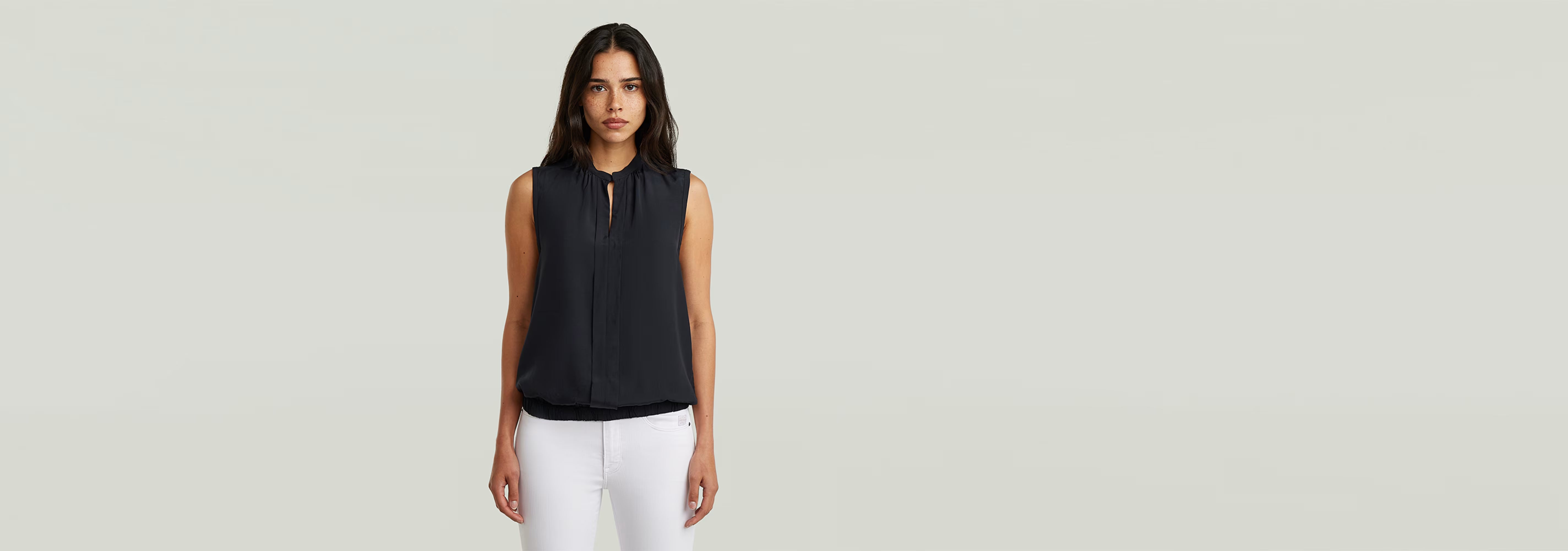 Top sin mangas Stand Up Collar en color negro con cuello mao y apertura, estilo elegante y moderno.