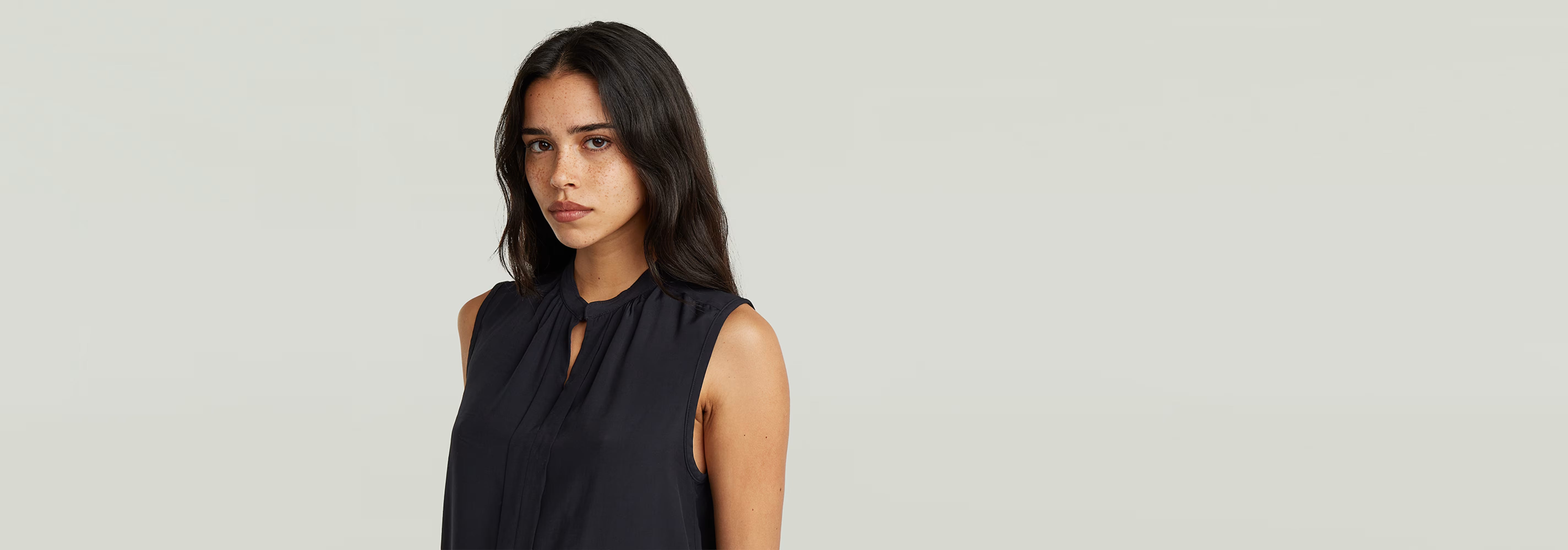 Top sin mangas Stand Up Collar en color negro, con cuello mao y un diseño elegante y moderno.