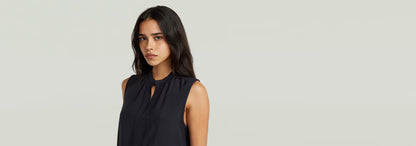 Top sin mangas Stand Up Collar en color negro, con cuello mao y un diseño elegante y moderno.
