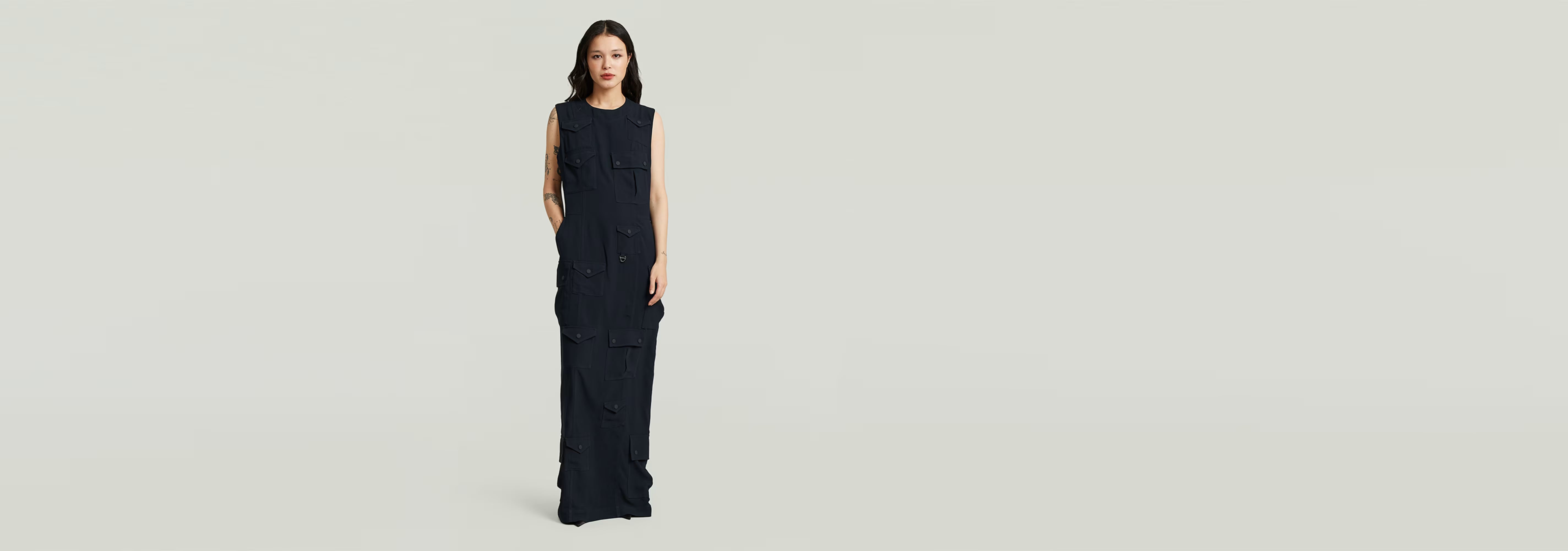 Vestido Long Pocket en modelo femenino, diseño elegante con bolsillo y tirantes anchos en color oscuro.