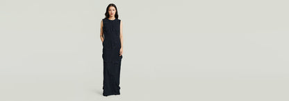 Vestido Long Pocket en modelo femenino, diseño elegante con bolsillo y tirantes anchos en color oscuro.