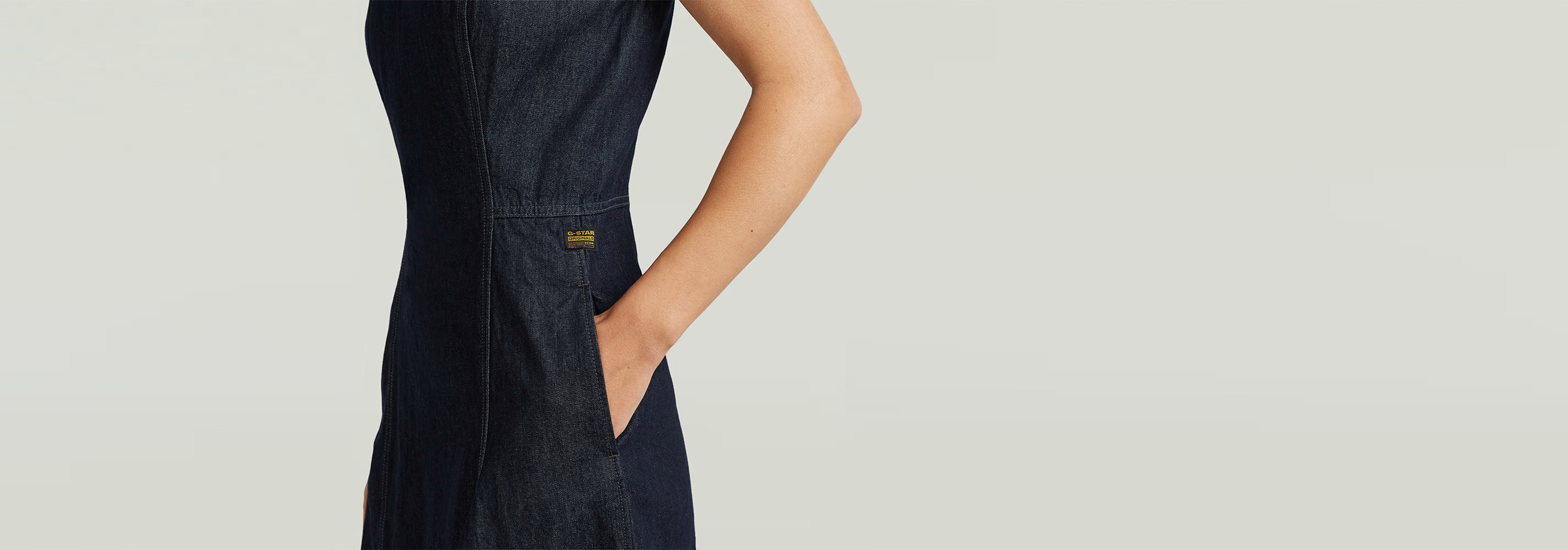 Vestido Vaquero Core Flare con corte superslim y tirantes anchos, mostrando detalles de la tela rígida.