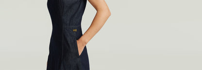 Vestido Vaquero Core Flare con corte superslim y tirantes anchos, mostrando detalles de la tela rígida.
